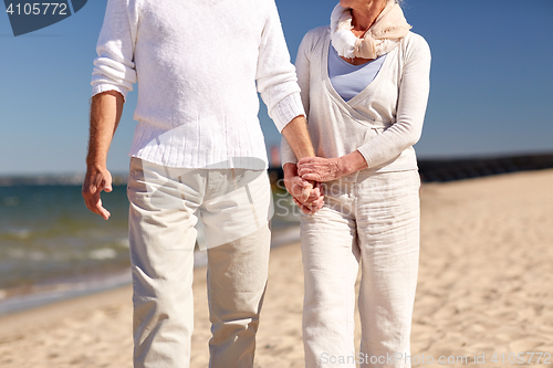 Image of close up of senior couple walking on summer beach