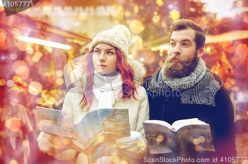 Image of happy couple with map and city guide in old town