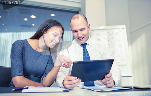 Image of smiling businesspeople with tablet pc in office