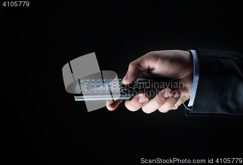 Image of close up of businessman hand with remote control