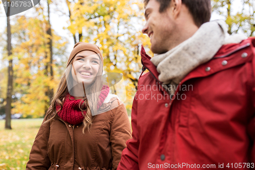 Image of happy young couple walking in autumn park