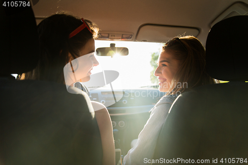 Image of happy teenage girls or women driving in car