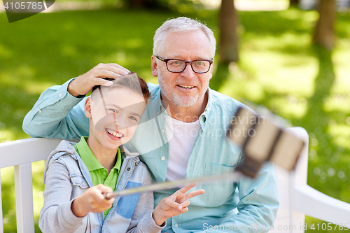 Image of old man and boy taking selfie by smartphone