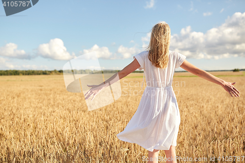 Image of happy young woman in white dress on cereal field