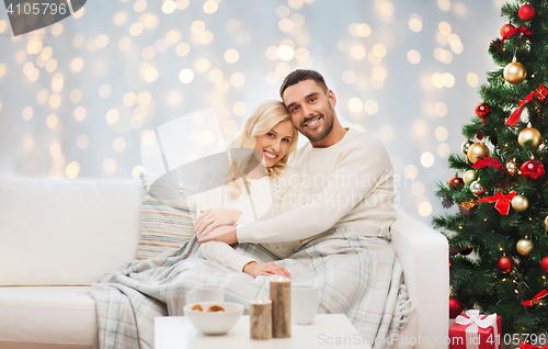 Image of happy couple hugging over christmas tree