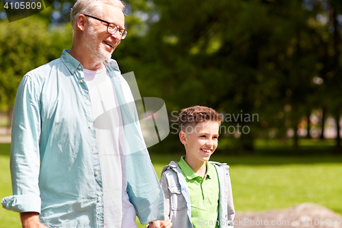 Image of grandfather and grandson walking at summer park