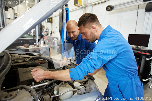 Image of mechanic men with wrench repairing car at workshop