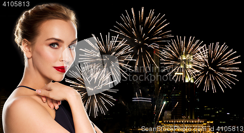 Image of beautiful woman in black over firework lights