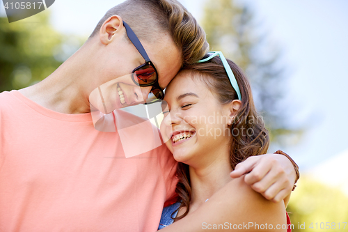 Image of happy teenage couple hugging at summer