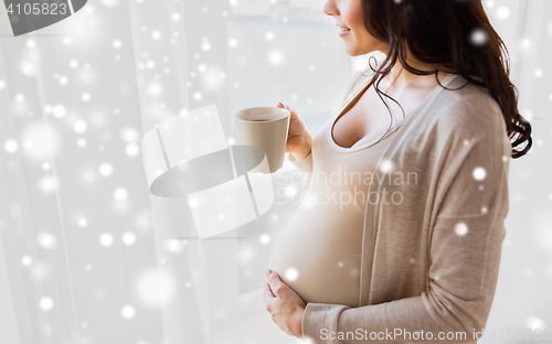 Image of close up of pregnant woman with tea cup at window