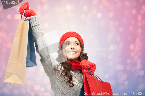 Image of woman with shopping bags over christmas lights 