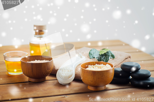 Image of body scrub, towel with brush and massage oil