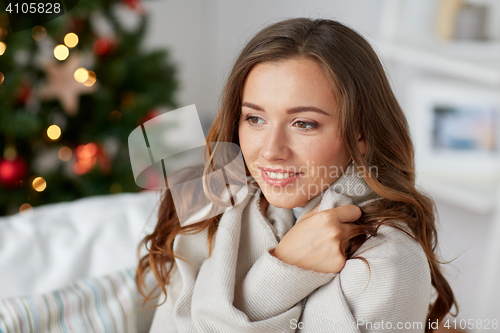 Image of happy young woman with plaid at home for christmas