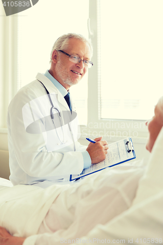 Image of senior woman and doctor with clipboard at hospital