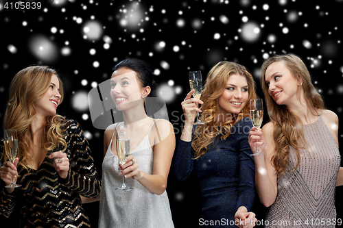 Image of happy women with champagne glasses over snow