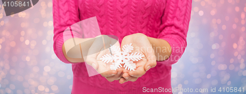 Image of close up of woman in sweater holding snowflake