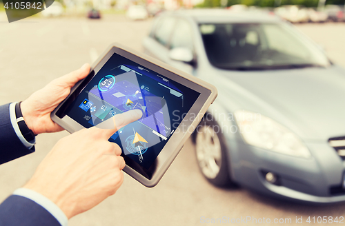 Image of male hands with navigator on tablet pc and car