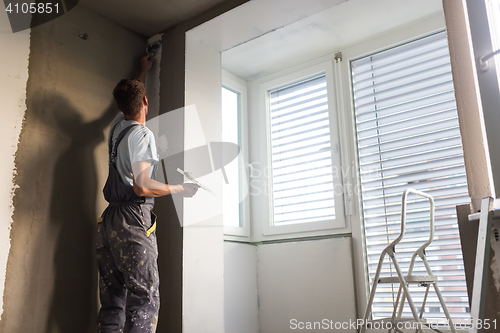 Image of Plasterer renovating indoor walls and ceilings. Construction finishing works.