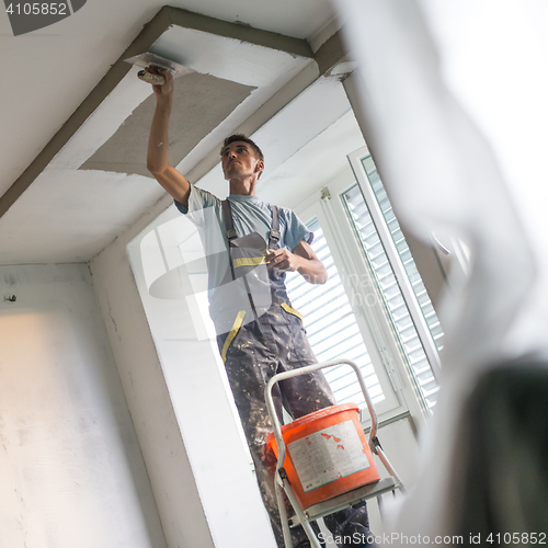 Image of Plasterer renovating indoor walls and ceilings. Construction finishing works.