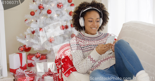 Image of Attractive woman listening to music at Christmas