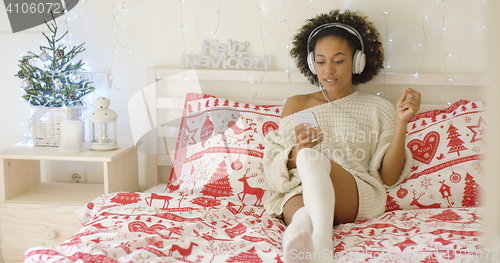 Image of Beautiful woman in long sweater on bed