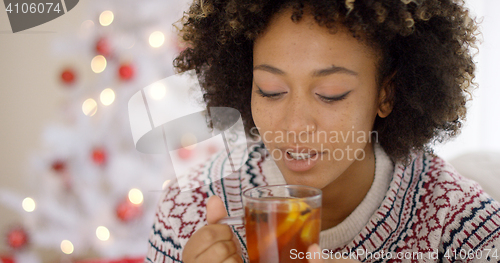 Image of Young woman sipping a cup of hot lemon tea