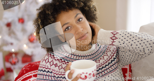 Image of Smiling friendly young woman relaxing at Christmas