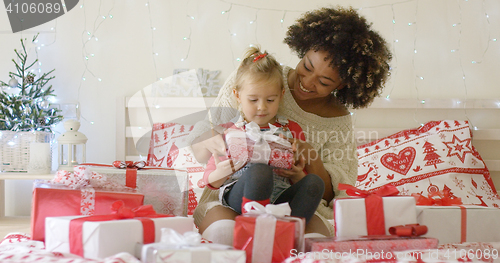 Image of Daughter and mother in bed with Christmas gifts