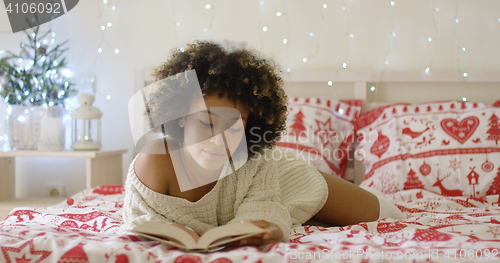 Image of Calm beautiful African woman reading in bed