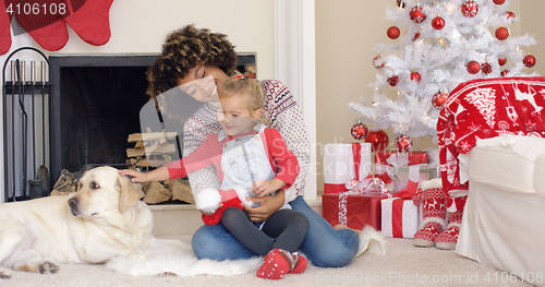 Image of Happy mother and child with dog on Christmas Day