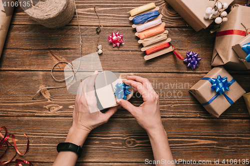 Image of Crop hands decorating present