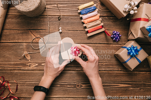 Image of Crop hands decorating present