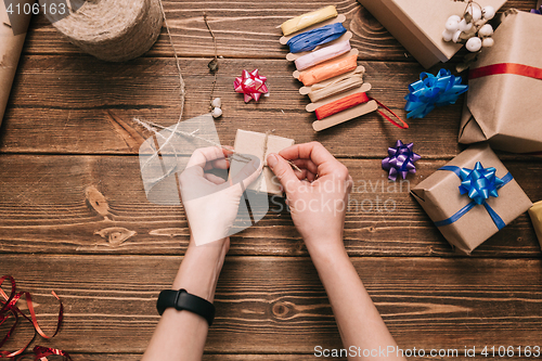 Image of Crop hands decorating present