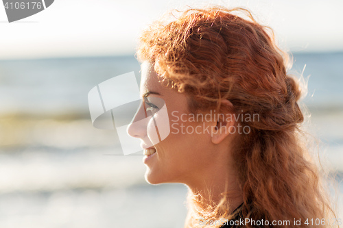 Image of happy young redhead woman face on beach