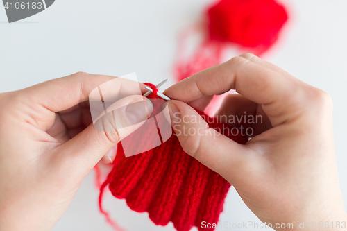 Image of close up of hands knitting with needles and yarn