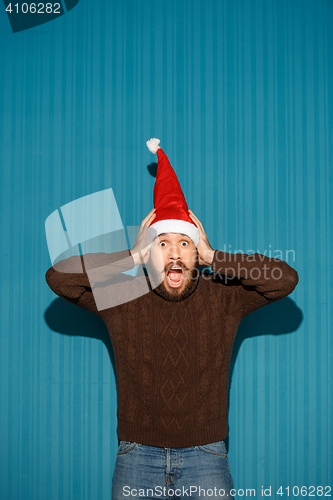 Image of Surprised christmas man wearing a santa hat