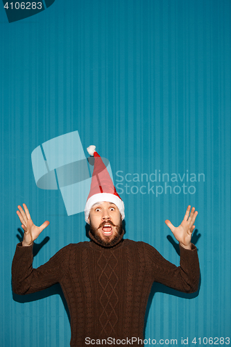 Image of Surprised christmas man wearing a santa hat