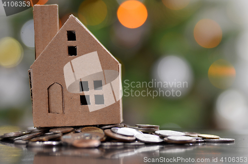 Image of Model of house with coins on wooden table