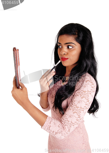 Image of Gorgeous woman putting on makeup.