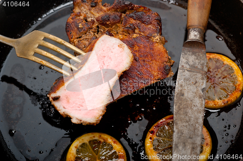 Image of pork chop seared on iron skillet