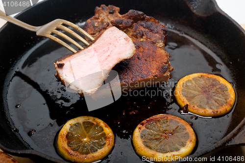 Image of pork chop seared on iron skillet