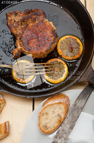 Image of pork chop seared on iron skillet