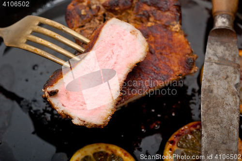Image of pork chop seared on iron skillet