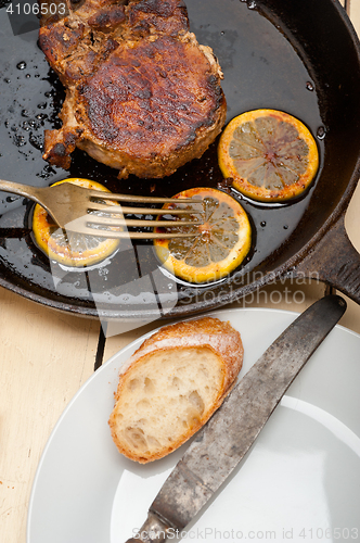 Image of pork chop seared on iron skillet