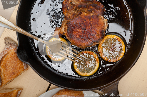 Image of pork chop seared on iron skillet