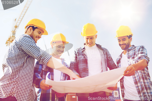 Image of group of builders with tablet pc and blueprint