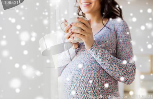 Image of close up of pregnant woman with tea cup at window
