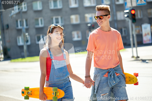 Image of teenage couple with skateboards on city street