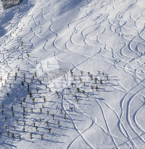 Image of Off-piste slope with traces from ski and snowboard at sun mornin