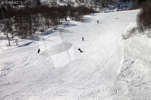 Image of Snowboarders and skiers on ski slope at sun winter day